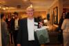 Sam Wean from W.B. Mason wins wine bottle from the Main Line Chamber of Commerce in  business card raffle